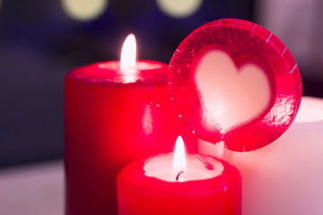 The concept of Love, Wedding, Proposal, Anniversary. A romantic evening with three burning red and white candles. Dark blurred background, close up