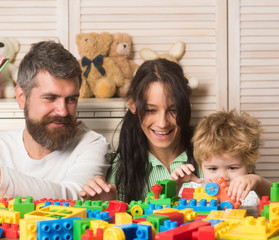 Family playing with colorful plastic blocks. Parents and kid