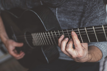 Fototapeta na wymiar Elderly man playing carbon fiber guitar