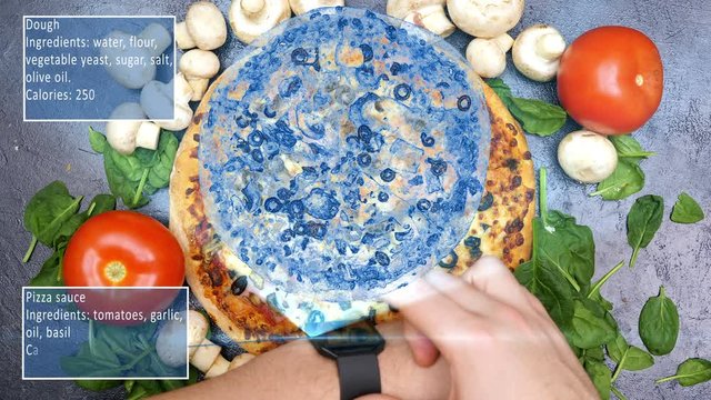 Futuristic concept of an app launching a hologram from digital smartwatch over a pizza and showing all the calories and ingredients of it