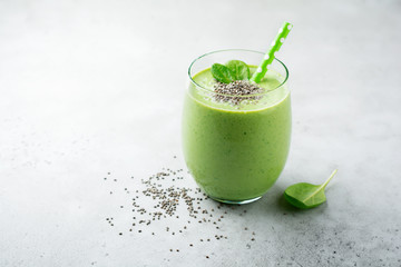 Vegetarian healthy green smoothie from avocado, spinach leaves, apple and chia seeds on gray...