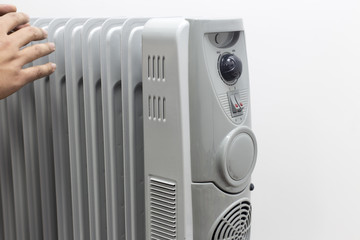 man lays his hands for oil heater for getting warm on white background