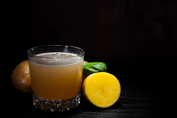 glass of potato juice on dark wooden background with copy space.