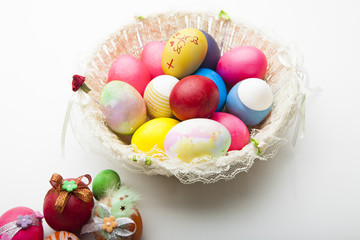 Colorful easter eggs in white  basket isolated on white