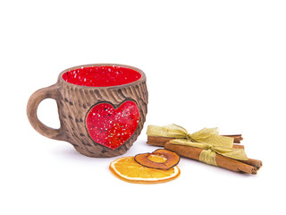 Valentine's Day still life. Clay cup with a red heart, dried orange, apple cuts and cinnamon sticks...