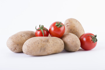 Potatoes and tomatoes on a white background. Potatoes on a white background. Red tomatoes with potatoes