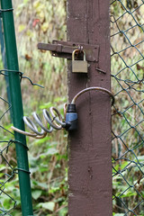 Vorhängeschloß, Fahrradschloß und Riegel an einem Pfosten