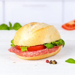 Brötchen Sandwich Baguette belegt mit Salami Schinken Quadrat auf Holzbrett
