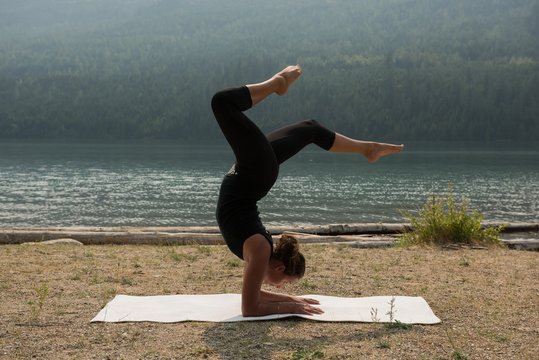 &nbsp;Fit woman doing acrobatic yoga near the sea coast