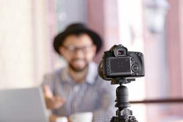 Naklejka premium Young blogger recording video in cafe