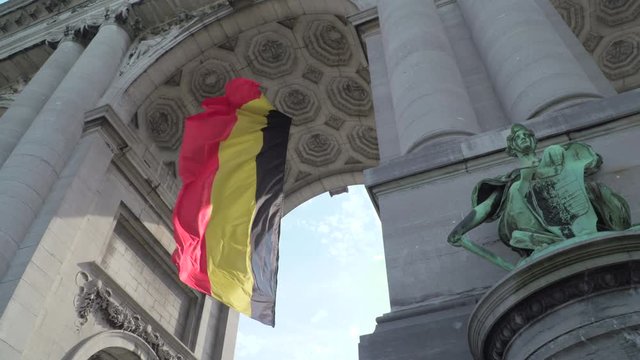 Huge Belgian flag waving in Triumphal Arch in Cinquantenaire Park in Brussels, Belgium ..Arch built in 1880 to celebrate 50 years of Belgian independence,