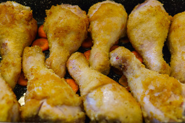 Chicken legs baked on the roasting pan in the oven.