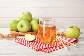 Glass of delicious apple juice on table