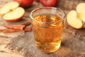 Glass of delicious apple juice on table