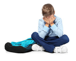 Depressed little boy on white background
