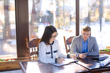 Young secretary refusing in handshaking with boss at cafe.