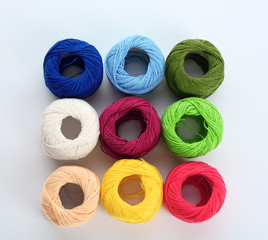 Colorful threads on white background, top view
