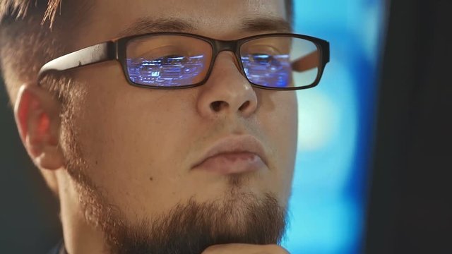 Young man working on computer in dark digital office