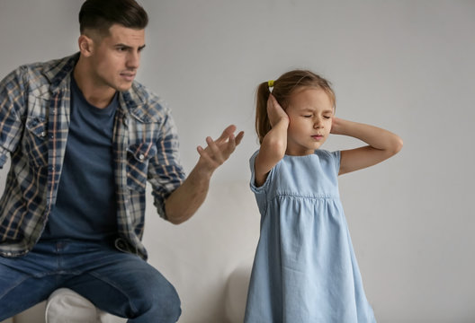 Man scolding his daughter at home