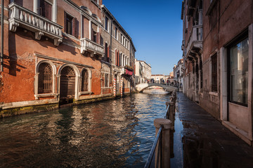 Fototapeta na wymiar VENICE, ITALY - JANUARY 02 2018: Venetian canal with bridge and colorful houses