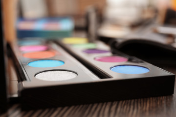 Fototapeta na wymiar Eyeshadow palette of professional makeup artist on dressing table, closeup