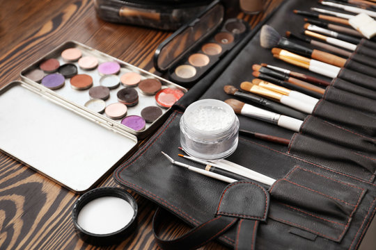 Brushes with cosmetics of professional makeup artist on dressing table