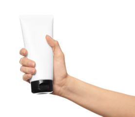 Young woman holding tube of hand cream on white background