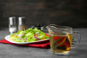 Jug with tasty apple vinegar on table