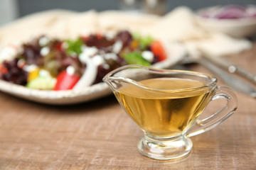 Gravy boat with tasty apple vinegar on table