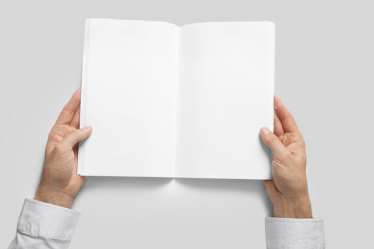 Man holding book with blank pages on white background. Mock up for design