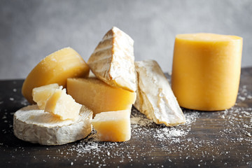 Different kinds of delicious cheese on wooden table