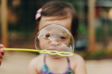 Little Girl Staring into Large Bubble