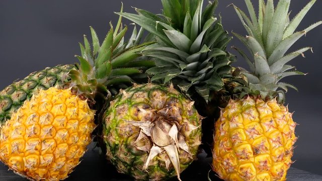 Rotating pineapple fruits isolated on a black background (not loopable)