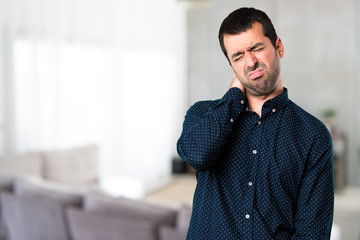 Fototapeta premium Handsome man with neck pain inside house