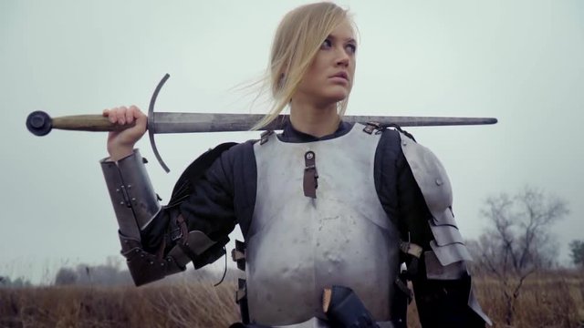 Jeanne d'Arc in armor with a sword on her shoulder