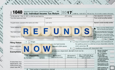 Macro close up of 2017 IRS form 1040 with REFUNDS NOW letters
