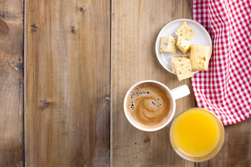 A table towel in a red cage, a glass of fresh orange juice and a fragrant coffee. Cut cheese. Place for writing text or advertising