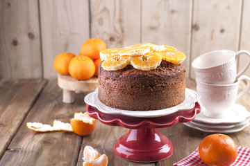 Homemade cupcake with tangerines on a white plate, for breakfast. cups for tea. wooden background, space for writing text or advertising