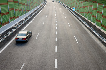A motorway enclosed with acoustic shields and cars in motion