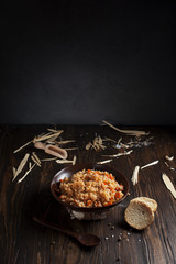 pilaf in a brown ceramic plate on a wooden table with bread and a wooden spoon