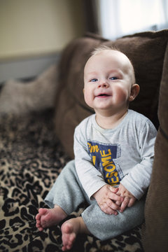 .little boy smiling sitting on the couch
