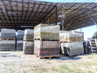 Tiles piled in pallets. Warehouse paving slabs in the factory for its production.