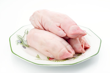 uncooked pork hands on decorated porcelain plate