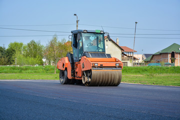 The roller aligns the new asphalt