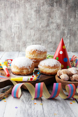 German donuts with jam and icing sugar. Carnival powdered sugar raised donuts with paper streamers.