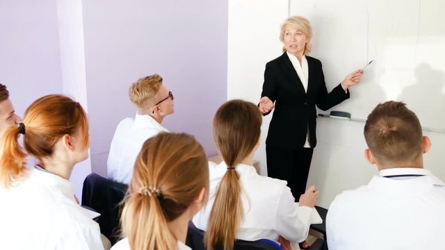 Female professor giving presentation for medical students in lecture hall