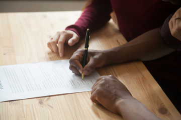 African american man signing contract, black man hand putting signature on official document,...