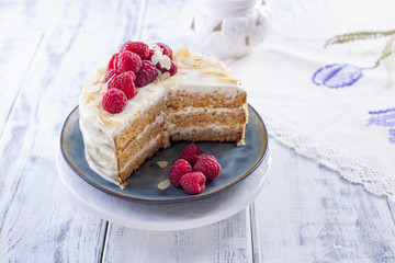 Cut the cake with white cream, for breakfast. A mango fruit. White background, tablecloth with lace, and free space for text or advertising.