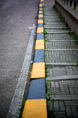 Vertical View Of a Stoned Stair Along The Street With Black and Yellow Markings.