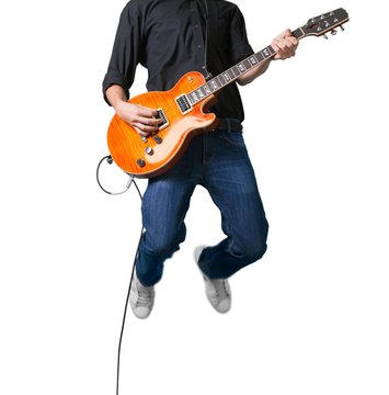 Portrait of a Musician Jumping while Playing an Electric Guitar © BillionPhotos.com
